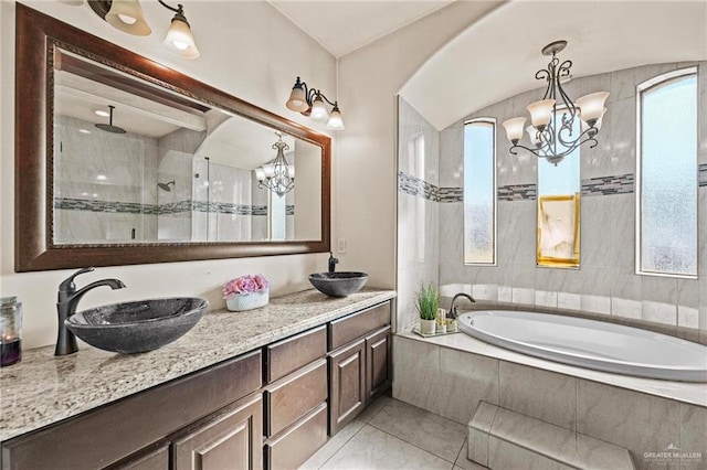 bathroom with tile patterned floors, a notable chandelier, vanity, and plus walk in shower