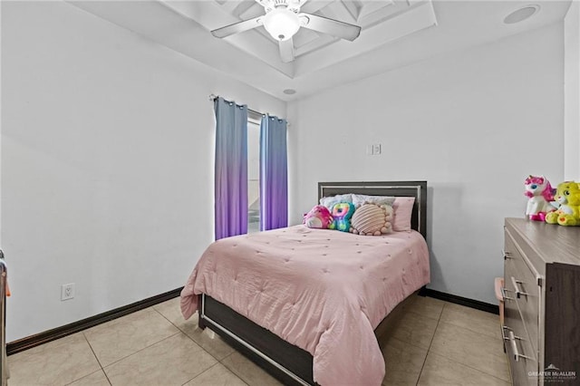 tiled bedroom with a raised ceiling and ceiling fan