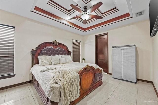 bedroom featuring a raised ceiling, ceiling fan, light tile patterned floors, and ornamental molding