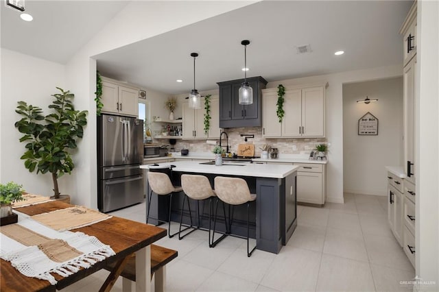 6317 Cardiff Ave, Edinburg, TX 78542 - kitchen with appliances with stainless steel finishes, tasteful backsplash, light countertops, an island with sink, and open shelves