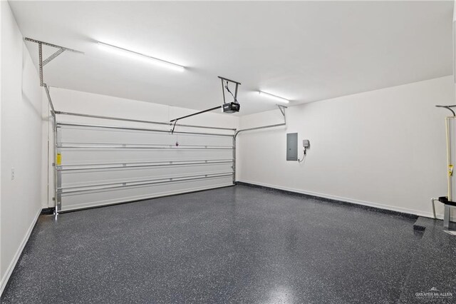 2312 Corales St, Mission, TX 78573 - garage featuring electric panel, a garage door opener, and baseboards