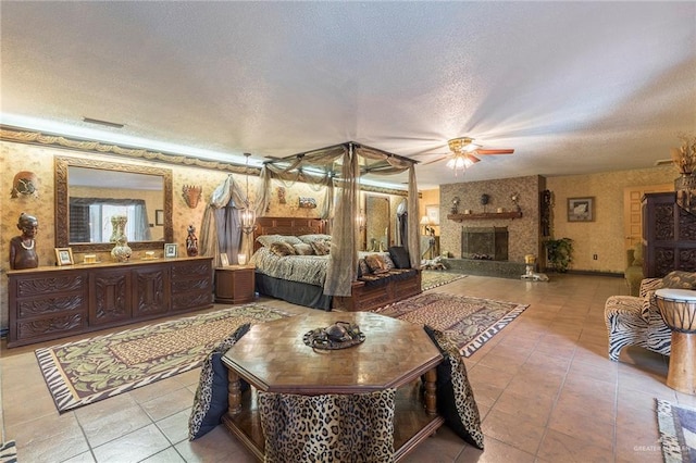 bedroom with light tile patterned floors, a textured ceiling, and a fireplace