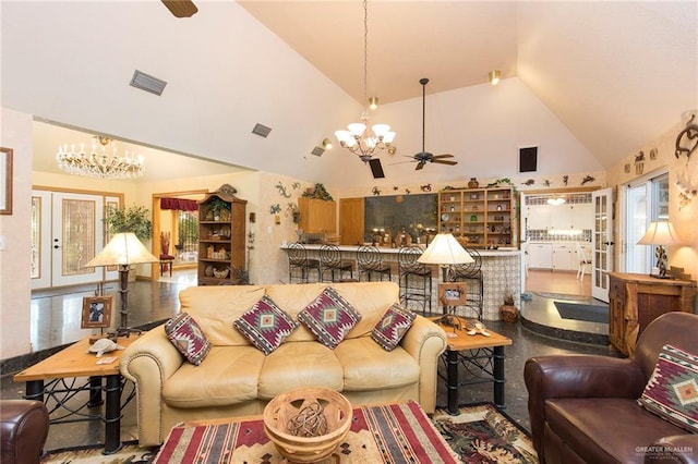 living room with ceiling fan with notable chandelier, high vaulted ceiling, and french doors