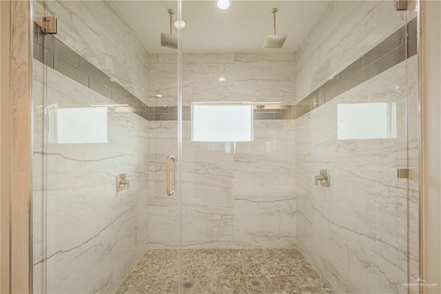 bathroom with a marble finish shower and visible vents