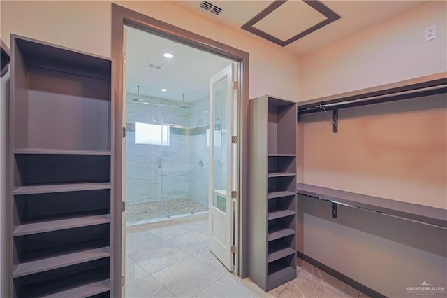 walk in closet featuring marble finish floor and visible vents