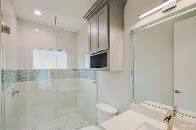 full bath with a stall shower, vanity, toilet, and recessed lighting