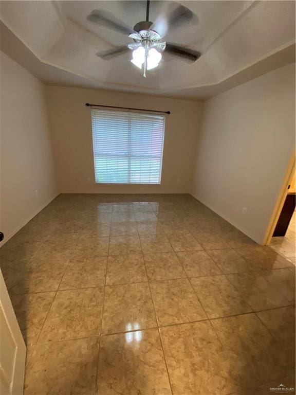 804 Ray St, Donna, TX 78537 - unfurnished room with light tile patterned floors, baseboards, a ceiling fan, and a raised ceiling