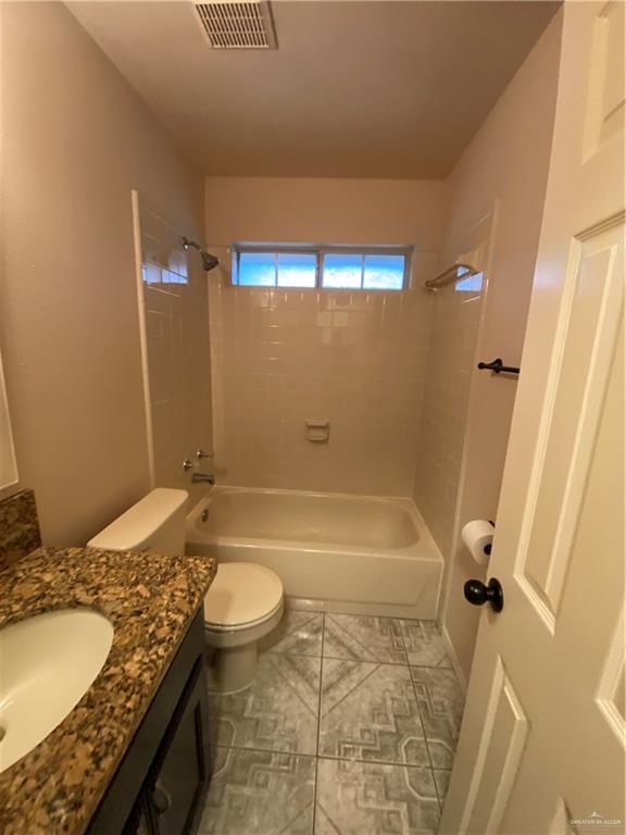 804 Ray St, Donna, TX 78537 - full bathroom featuring visible vents, toilet, vanity, and bathtub / shower combination