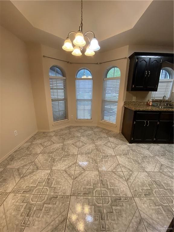 804 Ray St, Donna, TX 78537 - unfurnished dining area with baseboards, vaulted ceiling, a chandelier, and a sink