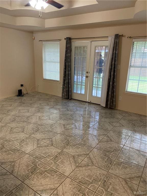 804 Ray St, Donna, TX 78537 - spare room featuring baseboards, french doors, a tray ceiling, and a ceiling fan