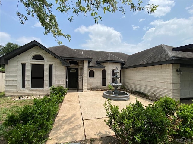 804 Ray St, Donna, TX 78537 - view of front of home featuring an attached garage, brick siding, and roof with shingles