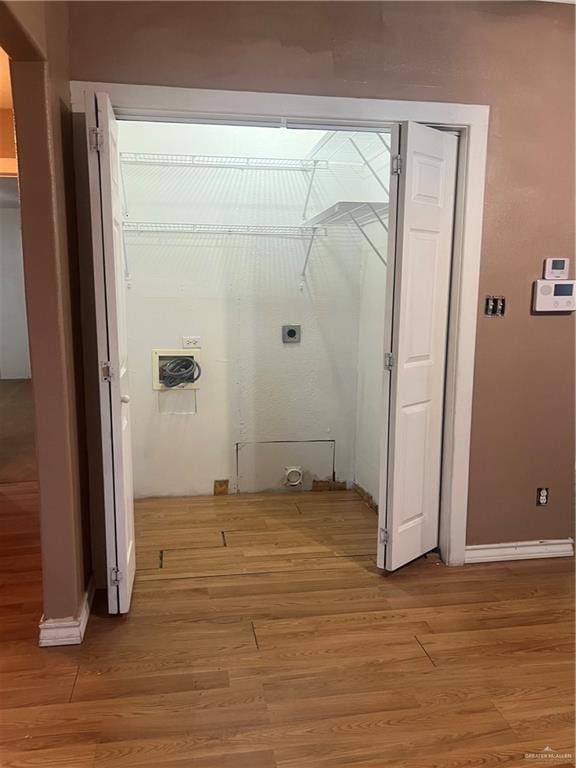 laundry area featuring hookup for an electric dryer and light hardwood / wood-style floors