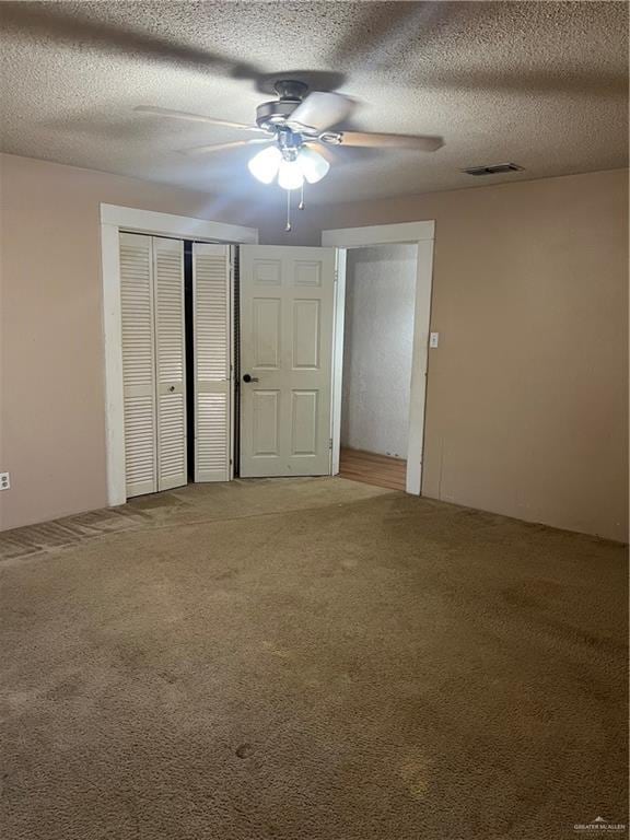 unfurnished bedroom featuring ceiling fan, carpet, and a textured ceiling