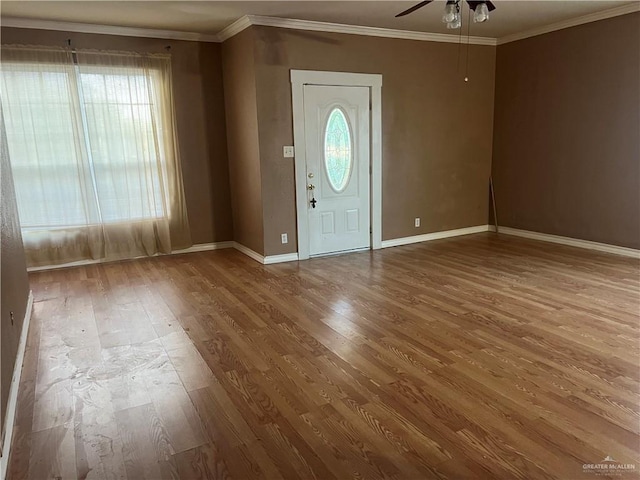 foyer entrance with wood-type flooring, ceiling fan, and ornamental molding