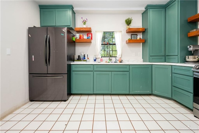 275 Violeta St, San Benito, TX 78586 - kitchen featuring open shelves, freestanding refrigerator, a sink, light countertops, and green cabinets