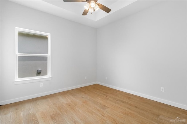 unfurnished room featuring baseboards, a ceiling fan, and light wood-style floors
