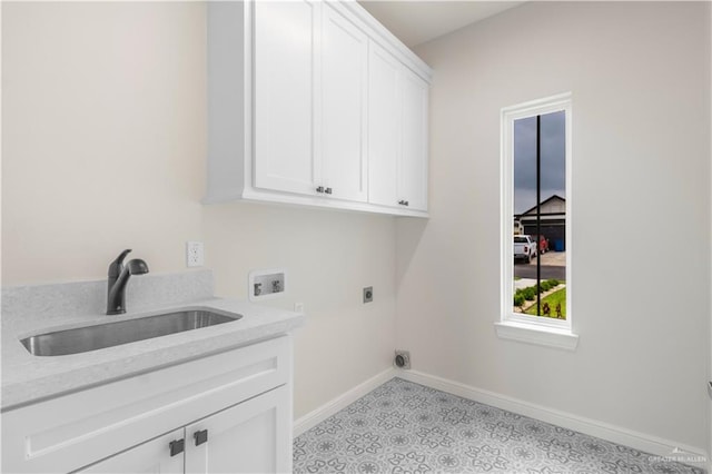 washroom featuring a sink, baseboards, washer hookup, cabinet space, and electric dryer hookup