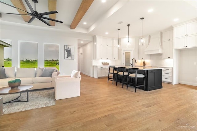 living area featuring baseboards, a ceiling fan, light wood finished floors, and recessed lighting
