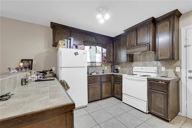 115 W Albatross Ave, Pharr, TX 78577 - kitchen featuring light tile patterned flooring, dark brown cabinets, white appliances, backsplash, and under cabinet range hood