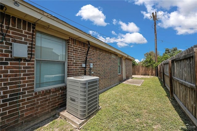 115 W Albatross Ave, Pharr, TX 78577 - view of side of property with brick siding, central AC unit, a lawn, and a fenced backyard