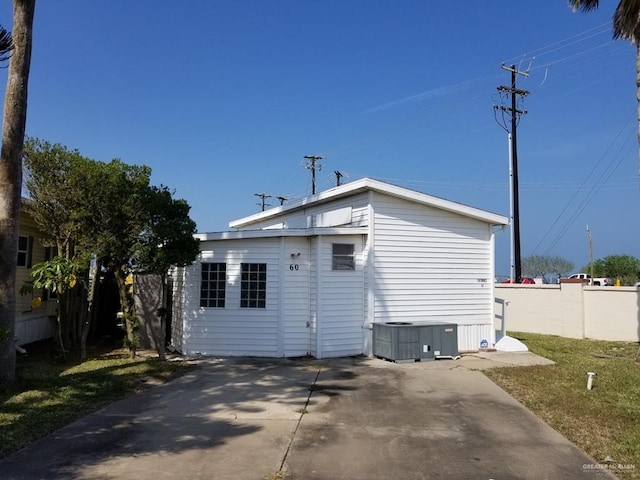 back of property featuring cooling unit and fence