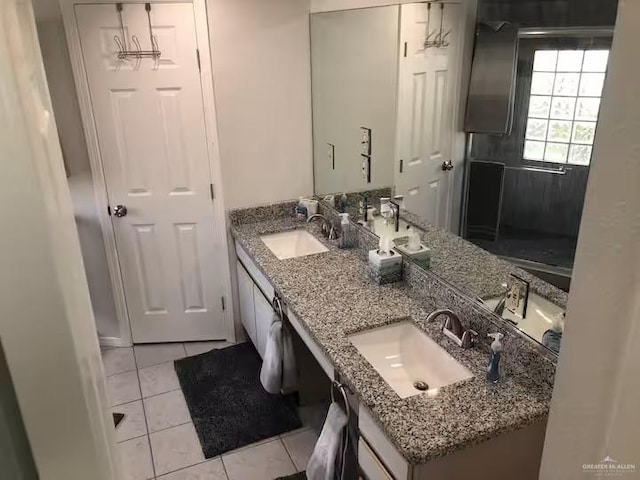 full bath featuring double vanity, a sink, and tile patterned floors