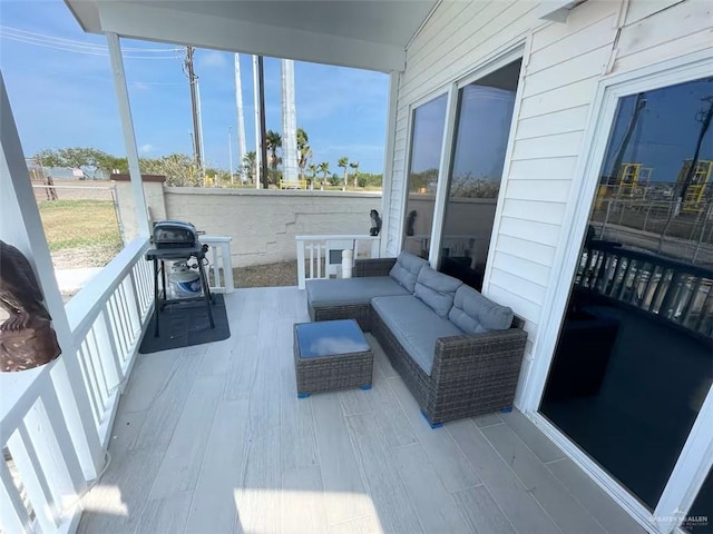 wooden terrace with grilling area and an outdoor living space