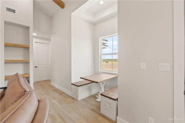 interior space with lofted ceiling with beams and light hardwood / wood-style floors