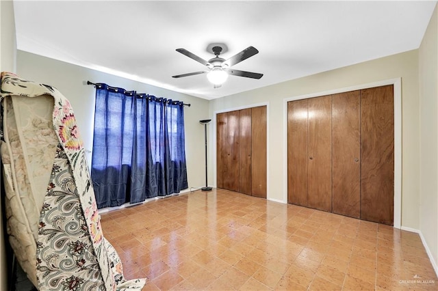 unfurnished bedroom with two closets and ceiling fan