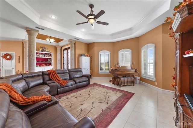 tiled living room featuring decorative columns, a raised ceiling, and a wealth of natural light