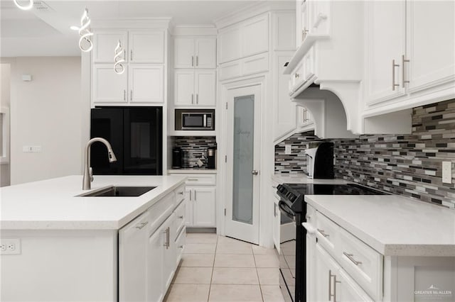 kitchen with sink, white cabinetry, refrigerator, black / electric stove, and a kitchen island with sink