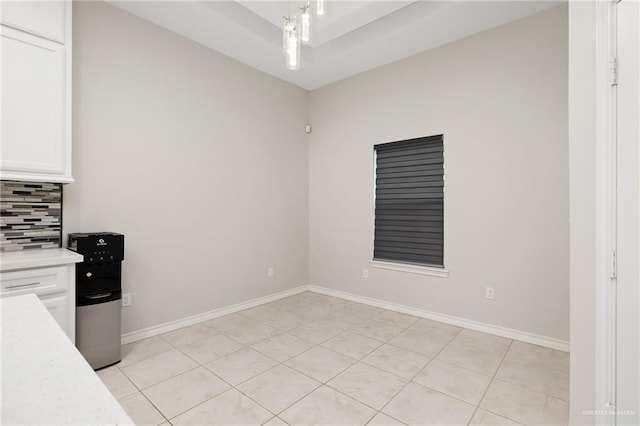 kitchen with white cabinetry, light tile patterned floors, and backsplash