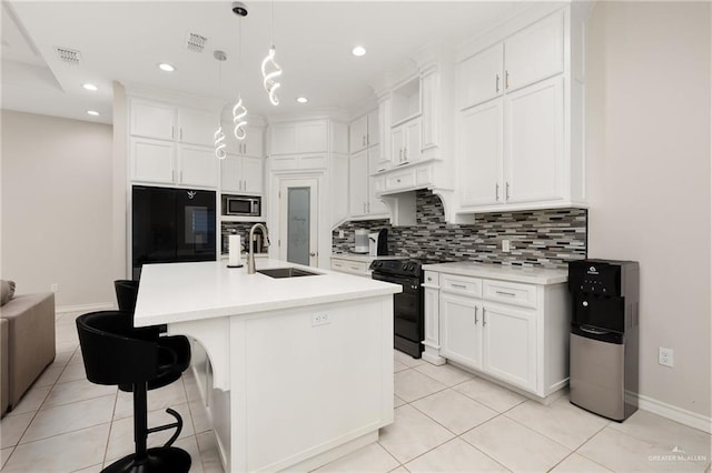 kitchen with stainless steel microwave, refrigerator, sink, hanging light fixtures, and electric range