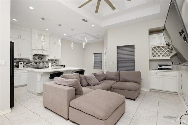 living room with coffered ceiling, light tile patterned floors, sink, and ceiling fan