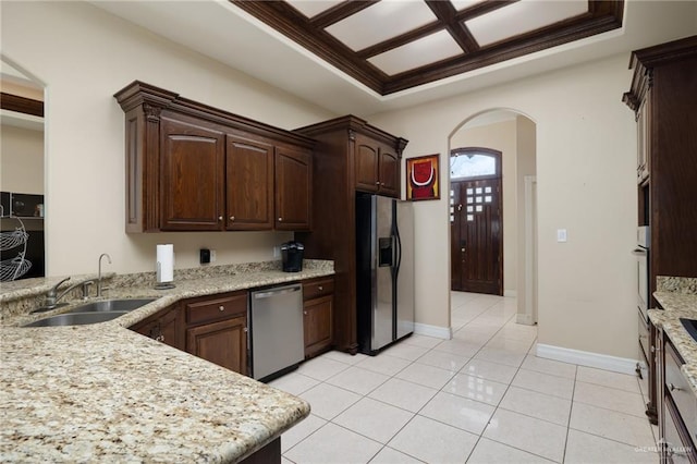 kitchen featuring sink, light tile patterned floors, dark brown cabinets, stainless steel appliances, and light stone countertops