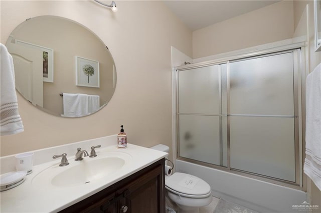 full bathroom featuring vanity, combined bath / shower with glass door, and toilet