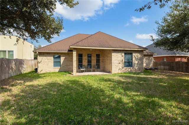 rear view of house featuring a patio area and a lawn