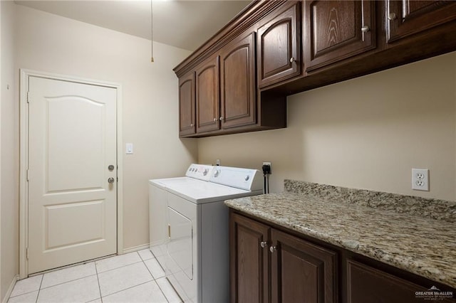 washroom featuring light tile patterned floors, cabinets, and washing machine and clothes dryer