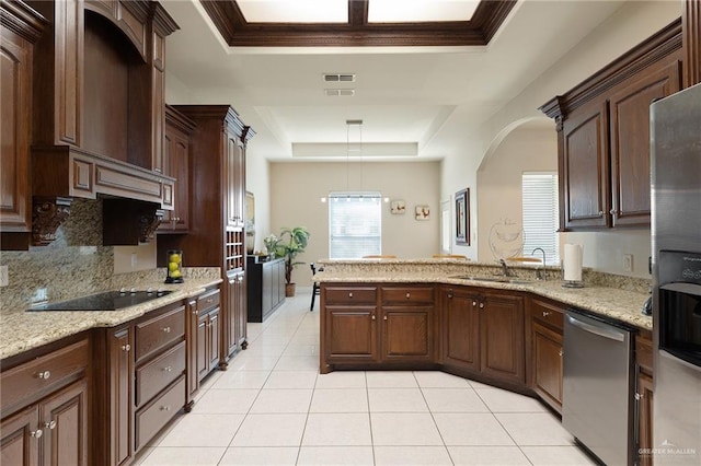 kitchen featuring sink, hanging light fixtures, a tray ceiling, stainless steel appliances, and light stone countertops