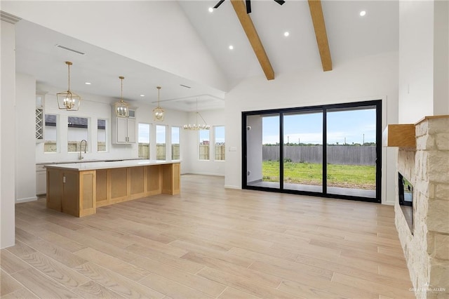1003 Bette St, Pharr, TX 78577 - kitchen featuring light wood finished floors, a fireplace, light countertops, a chandelier, and a large island