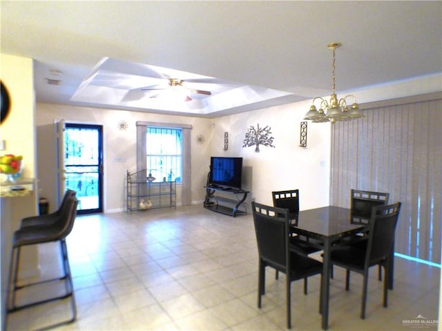 dining room with a tray ceiling, baseboards, and ceiling fan with notable chandelier