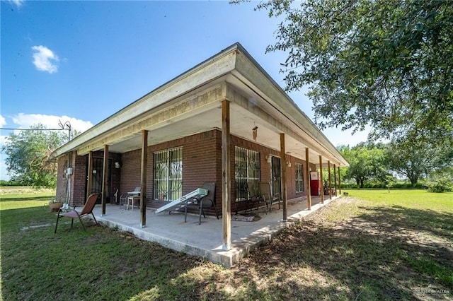1806 N Doolittle Rd, Edinburg, TX 78542 - view of home's exterior featuring a yard, brick siding, and a patio