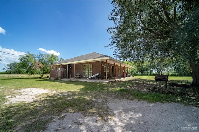 1806 N Doolittle Rd, Edinburg, TX 78542 - view of front facade with a front yard, a patio, and brick siding