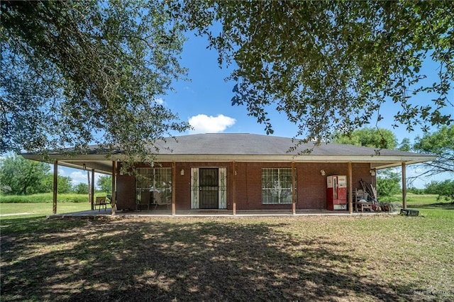 1806 N Doolittle Rd, Edinburg, TX 78542 - rear view of house with a yard, a patio, and brick siding