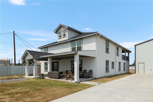 rear view of house with a lawn, a patio area, and an outdoor hangout area