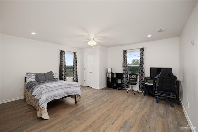 bedroom featuring multiple windows, ceiling fan, and hardwood / wood-style flooring