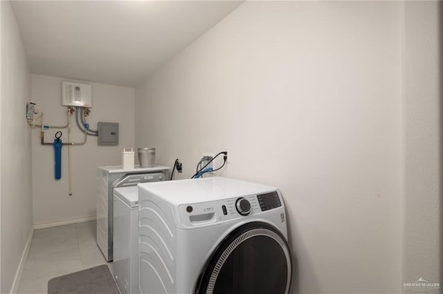 washroom featuring washing machine and dryer, light tile patterned floors, electric panel, and water heater