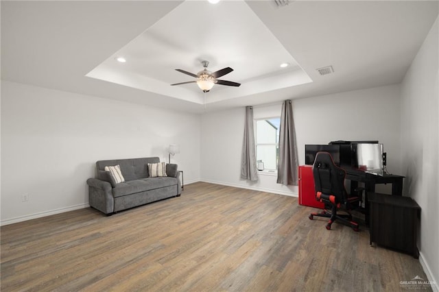 office area featuring a tray ceiling, ceiling fan, and hardwood / wood-style flooring