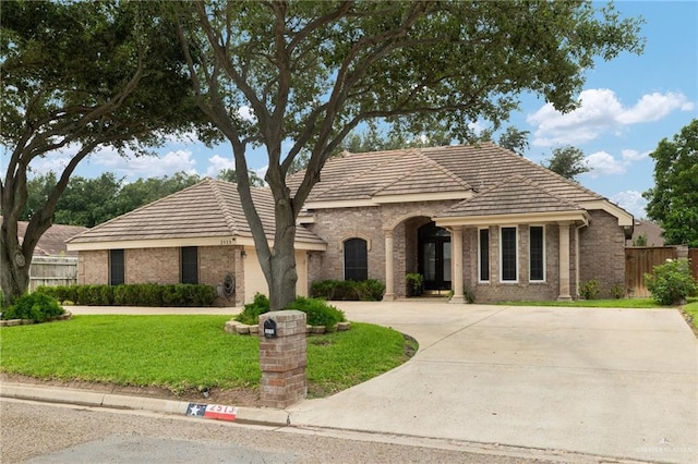 2513 Kings Dr, Edinburg, TX 78539 - view of front facade featuring brick siding, curved driveway, and a tiled roof