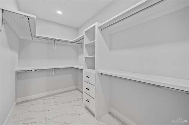 walk in closet featuring light marble finish floors